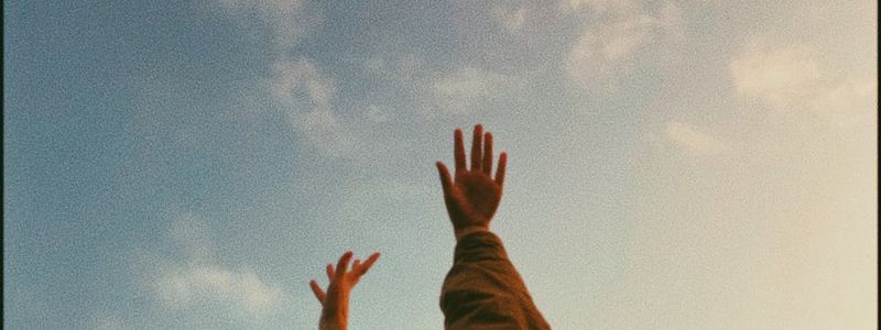 A woman stretching her arms towards the sky.